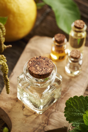 Bottles of aromatherapy essential oil with fresh lemon fruit and melissa leavesの写真素材