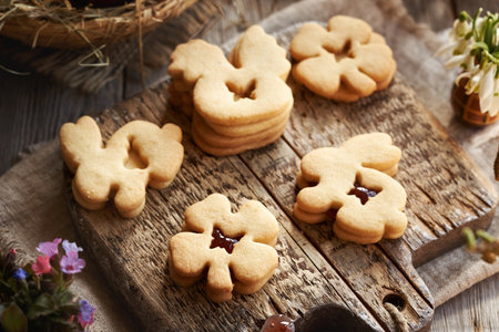 Homemade animal shaped Easter cookies filled with marmalad, with lungwort flowers in springの写真素材