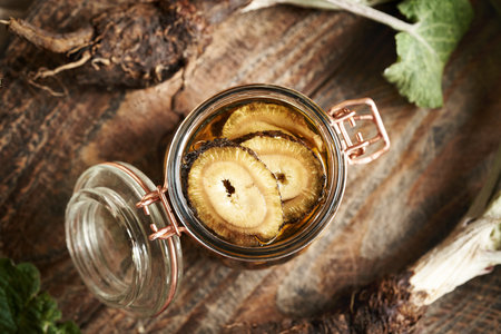 Burdock root and alcohol in a glass jar - prepration of herbal tincture, top viewの写真素材