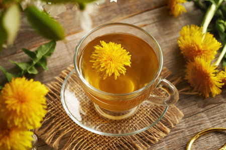 A glass cup of dandelion tea on a wooden table. Herbal medicine.の写真素材