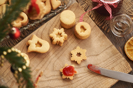 Homemade Linzer Christmas cookies being filled with red marmalade, top viewの写真素材