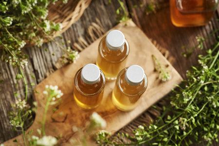 Bottles of homemade herbal tincture made of blooming shepherd's purse plantの写真素材