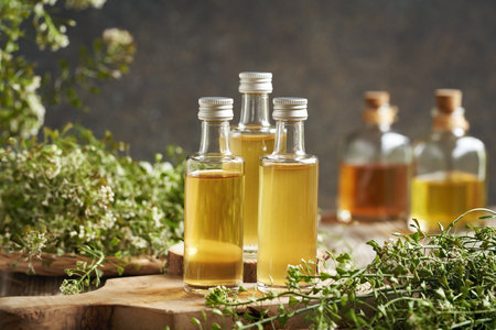Three bottles of herbal tincture with fresh blooming shepherd's purse plant in springの写真素材