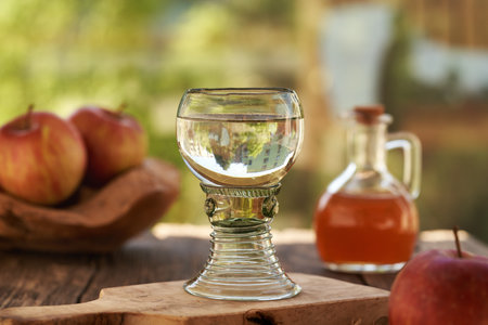 A cup of water with a little apple cider vinegar on a table outdoorsの写真素材