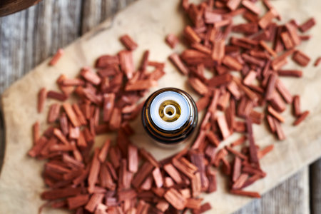 Red sandalwood oil in a brown glass bottle on a table, top viewの写真素材