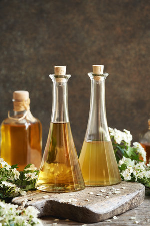 Bottles of herbal tincture with fresh hawthorn flowers in springtimeの写真素材
