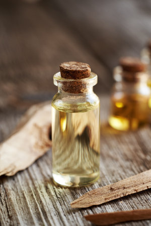 A bottle of aromatherapy essential oil with pieces of white sandalwoodの写真素材