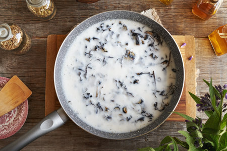 Macerating chopped comfrey or knitbone root in rendered pork lard - preparation of homemade herbal ointmentの写真素材
