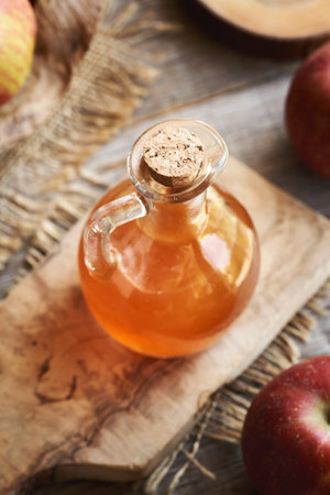 Apple cider vinegar in a glass jug on a tableの写真素材