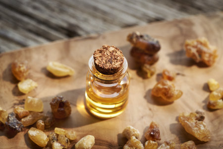 A glass bottle of frankincense essential oil on a tableの写真素材