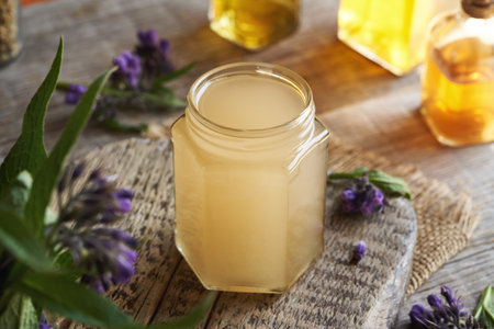 Homemade comfrey or knitbone root ointment made with hot rendered pork lard in springの写真素材