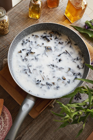 Homemade production of comfrey root ointment using rendered pork lard in a panの写真素材