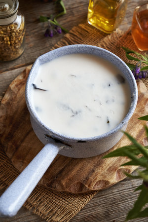 Preparation of comfrey root ointment using rendered pork lard in a saucepan in springの写真素材