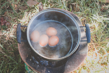 Egg in boiling water.Camp cookingの写真素材