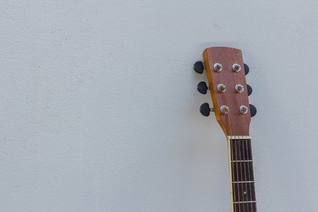 head of acoustic guitar on white wall.の写真素材