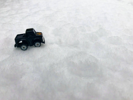Mini toy maket black CUV car in the snow winter background cold weather problems roadの写真素材