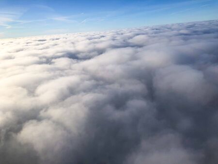 Sky view on the plane,Beautiful sky above clouds with dramatic light. Cabin view from airplane,blue sky background with clouds.の写真素材