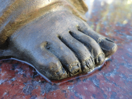 Foot of an angel. Details of a sculpture placed on granite slab.の写真素材