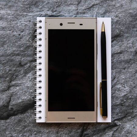 Still life: smartphone, notebbook and pen. Flat lay