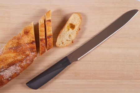 Wooden cutting board with sliced white bread and knife