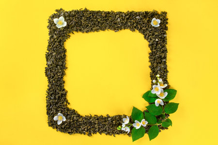 Yellow background with square frame of dried tea leavesの写真素材
