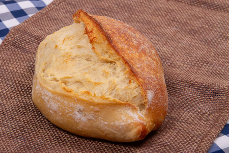 Loaf of Freshly baked homemade traditional french bread on rustic fabric backgroundの写真素材