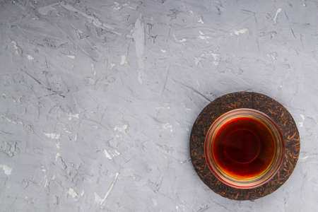 Pu erh tea cake and chinese tea cup on plaster background with place for textの写真素材