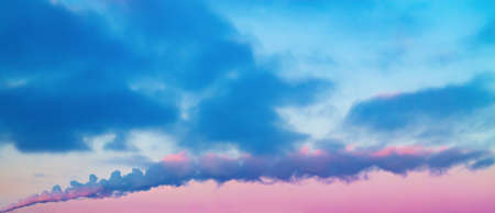 Blue-purple bright contrast cloudy sky background with smoke plume spreading horizontallyの写真素材