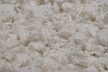 Protein-rich dairy product close-up. cottage cheese texture background. side view. selective focus.