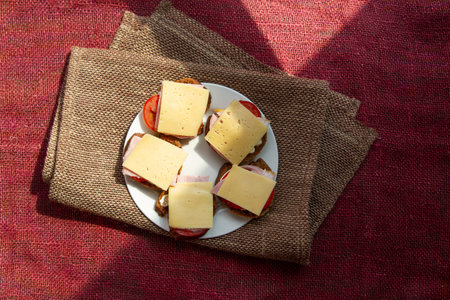 Five home-made sandwiches lie on white plate served on rustic fabric backgroundの写真素材