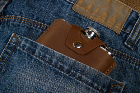 Hip flask in leather case in jeans pocketの写真素材