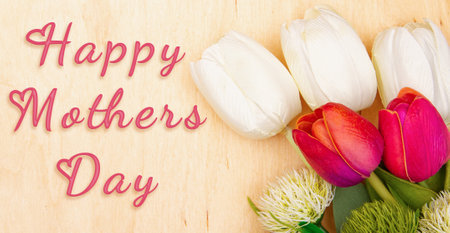 Tulip flowers on wooden background with inscription Happy Mother's Dayの写真素材