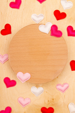 A lot of small hearts on wooden background with copy space. Greeting card with Heartfelt emotions on natural wood.の写真素材
