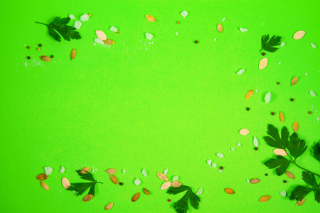 Bold and striking green background with greens, coarse salt, pumpkin seeds and peppercorns