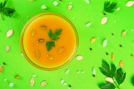 Bowl of tasty pumpkin cream soup on Lush green canvasの写真素材