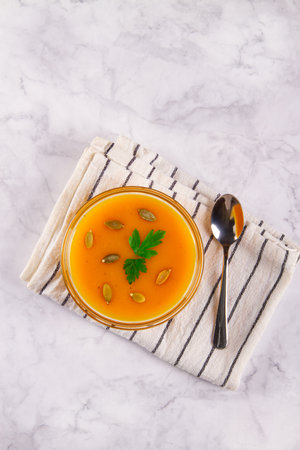 Creamy pumpkin soup with a smooth texture, served on a marble background with empty space for additional elements.の写真素材