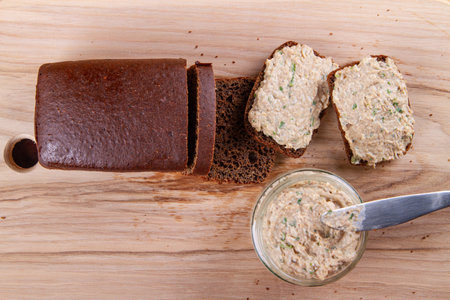 Delightful pate and slices of bread arranged tastefully on wooden table, capturing attention in flat lay perspectiveの写真素材