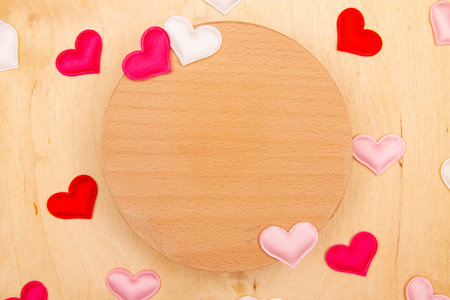 A lot of small hearts on wooden background with copy space. Greeting card with Wooden rustic charm and scattered hearts.の写真素材