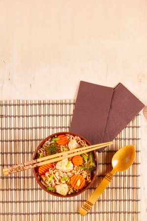 Stir fry noodles with vegetable in brown clay bowl on wooden backgroundの写真素材