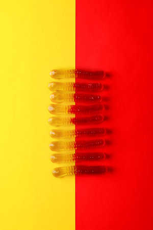 Gummi worms isolated on plain red and yellow background