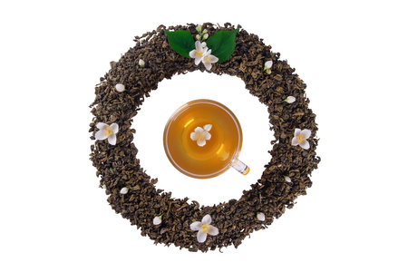 Mockup of dried tea leaves and fresh jasmine flowers shaped in round Frame whith tea cup in center isolated on clean white background with clipping pathの写真素材
