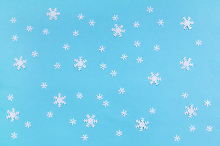 Blue winter background with confetti snowflakes. First snowfall concept. Top viewの写真素材