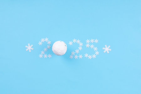 Minimalist New Year 2025 design showing the number 2025 created from small white snowflakes on bright blue backgroundの写真素材