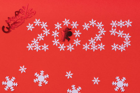 Merry Christmas and Happy New Year 2025 greeting card. White snowflakes on red backgroundの写真素材
