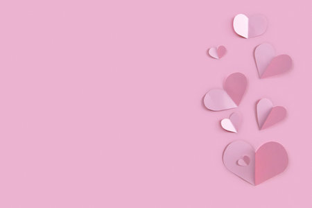 Many paper confetti hearts on pink background. St. Valentine's day banner templateの写真素材
