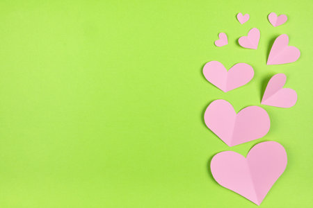 Pink hearts on plain light green background with blank spaceの写真素材