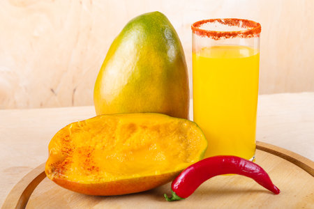 Fresh mango and red chili pepper on wooden backgroundの写真素材