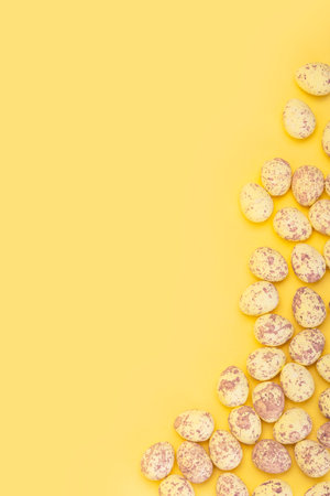 Vertical banner with small easter eggs on yellow background with empty spaceの写真素材
