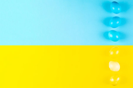 Two colors yellow and blue easter egg background with copy spaceの写真素材