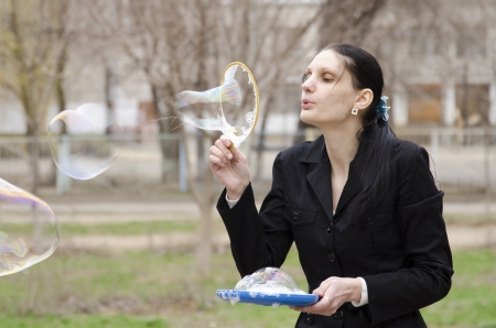 A girl inflates a big bubble, the bubble burstsの写真素材